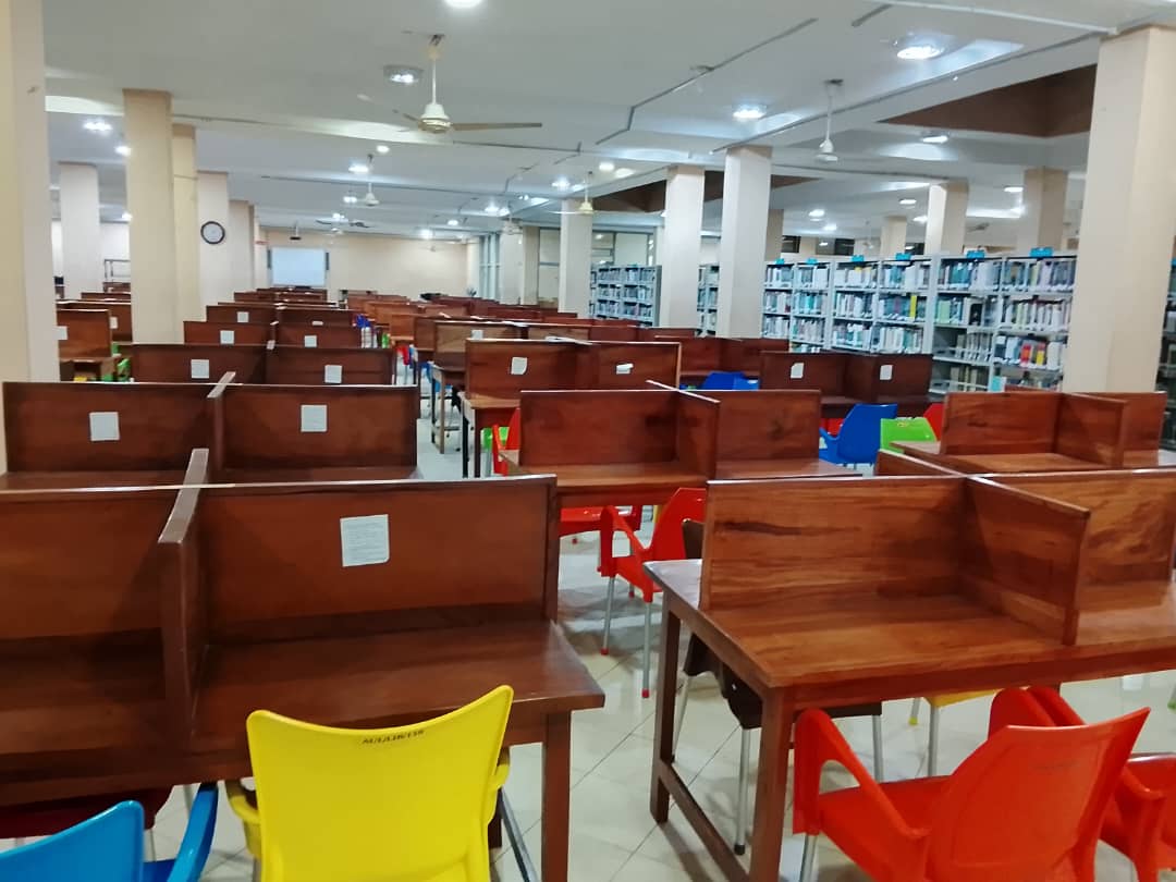 Study desks in front of open book stacks in the main library