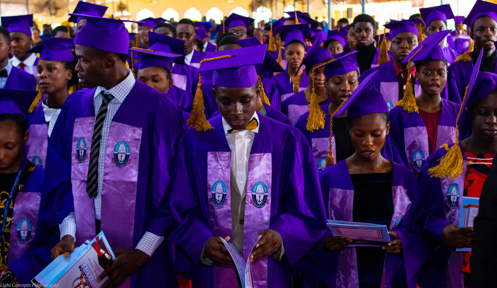 Matriculating students holding ceremony programmes
