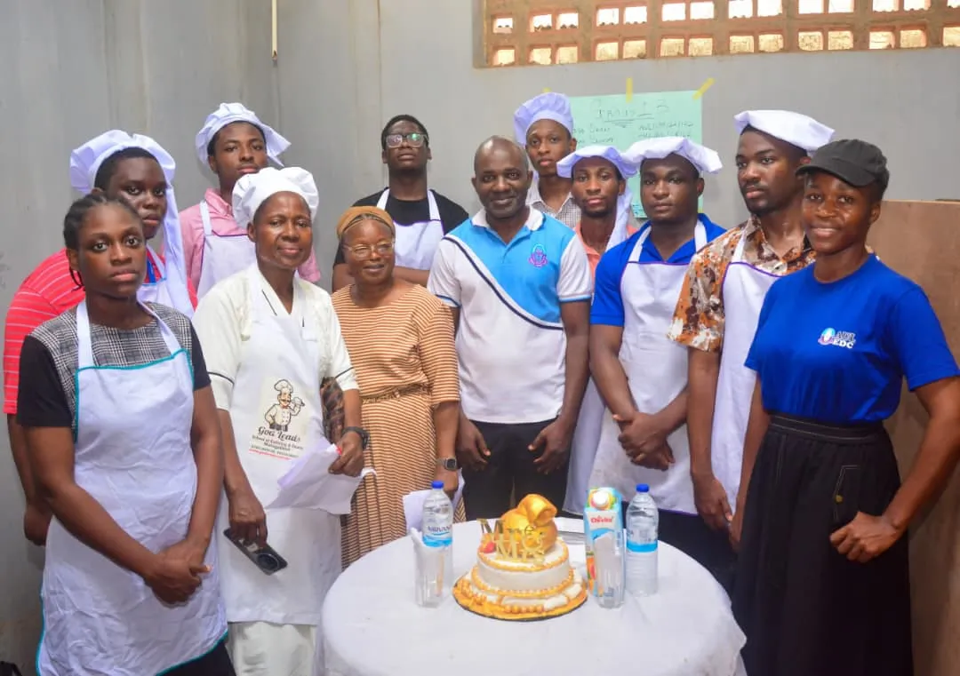 Students displaying a cake during catering training