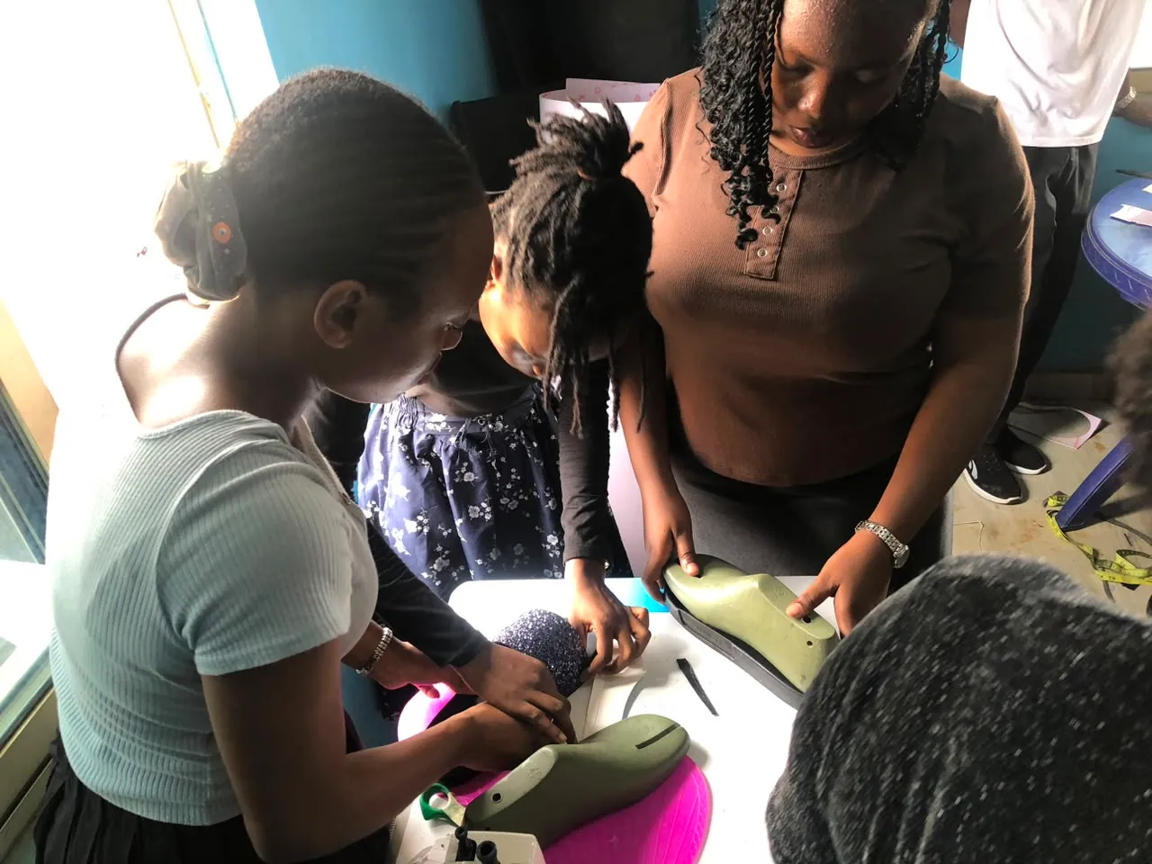 Students learning shoemaking techniques